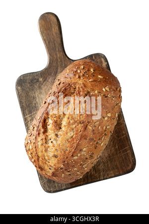 Organic Seeded Sourdough loaf resting on a wooden cutting board isolated on White background with clipping path, characterized by its use of organic i Stock Photo