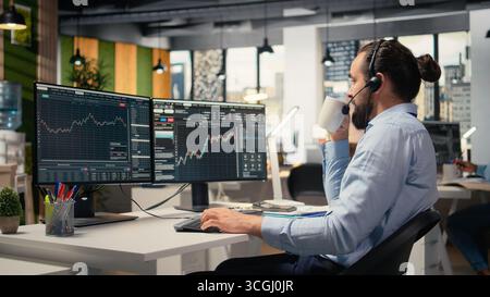 Financial advisor in office offers personalized investment guidance during live calls with clients. Consultant talking in headset mic, helping customers build tailored portfolio Stock Photo