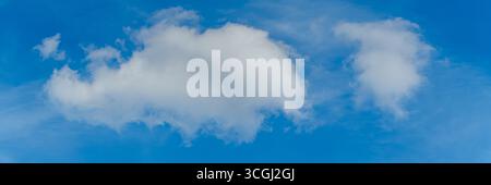 Single cumulus cloud against blue sky, photographed in daylight, panorama Stock Photo