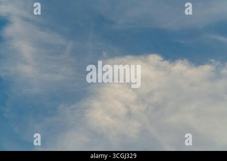 Combination of cumulus and cirrus cloud formations in daylight blue sky. Stock Photo