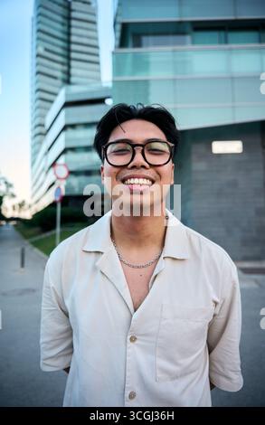 Young man wearing eyeglasses smiling outdoors, portrait of happiness Stock Photo