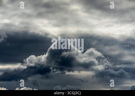 Dark cumulonimbus clouds forming in an overcast sky, photographed in daylight before rainfall Stock Photo