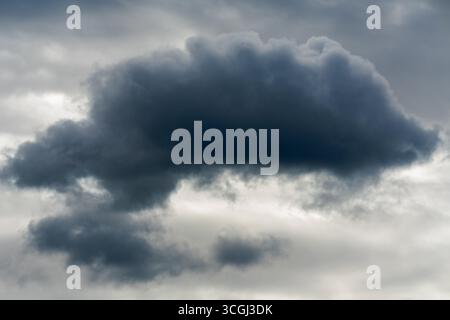 Cumulus clouds are low-level clouds that appear as dense, puffy formations with clearly defined edges. Stock Photo