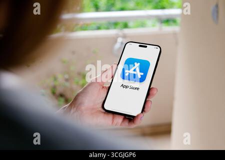 AppStore icon on iPhone screen. Woman holding a mobile phone in her hand with App Store logotype on screen. AppStore icon on iPhone screen. Woman hold Stock Photo