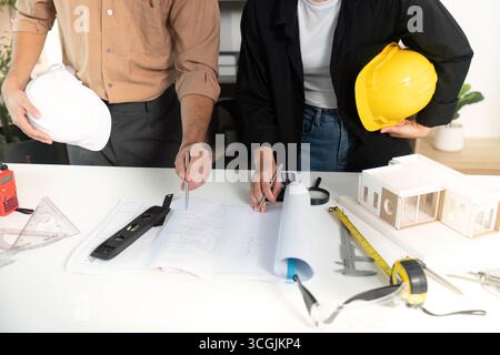 Architects Collaborating on Building Plans and Models Stock Photo