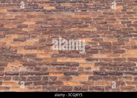 Low angle view of a texture background featuring an exterior vintage brick wall  in varying shades of brown and beige Stock Photo