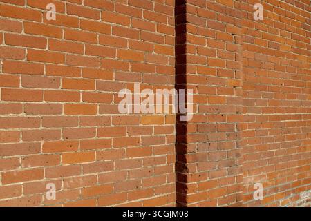 Full frame abstract texture background of a weathered old orange clay brick wall texture background Stock Photo