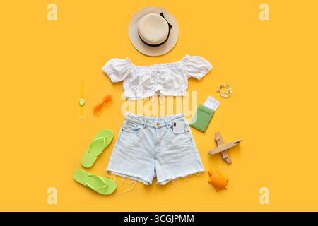 Composition with clothes and beach accessories on yellow background Stock Photo