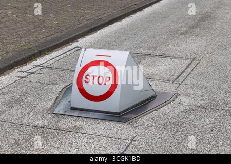 A "STOP" sign with an "SOS Toegang" (SOS Access) logo on a triangular white marker, set into the ground, indicating an emergency access point. Stock Photo