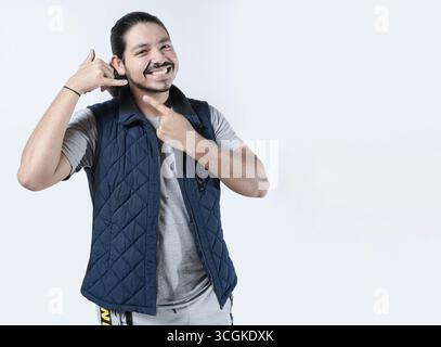 Smiling man gesturing call me on isolated background. Young man makes a calling gesture on a white background Stock Photo
