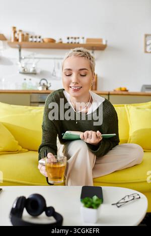 Relaxed atmosphere as a young woman sips tea while jotting down thoughts at home. Stock Photo