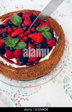 New York cheesecake with berries decorated with fresh mint, on a table. Homemade desserts. Directly above. Stock Photo