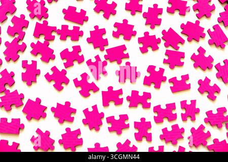 Different pink puzzle pieces on white table background Stock Photo