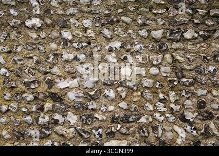 Close-up of a traditional flint stone wall showing rough natural texture and irregular pattern Stock Photo
