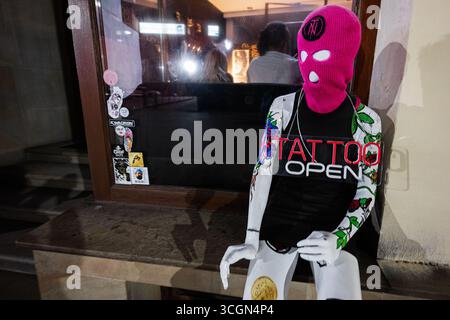 Rzeszow, Poland - August 22, 2025: A mannequin displaying tattoos outside a shop in Rzeszow, Poland during the night. Stock Photo