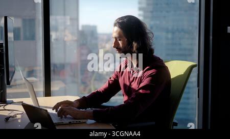 Focused man working on laptop in office Stock Photo