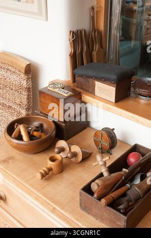 Various vintage woodworking tools and materials are organized on a wooden table in a workshop, showcasing craft and creativity under natural light. Stock Photo