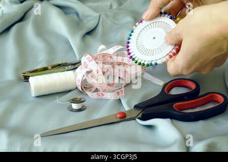 Sewing as analog hobby for stress relief and creativity. Hands working with needles, pins and fabric. Digital detox, craft therapy, calming activity Stock Photo