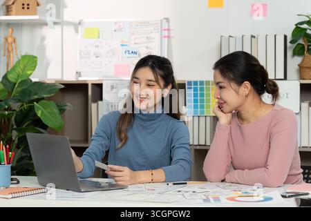 UX and UI designers discussing project ideas with laptop Stock Photo