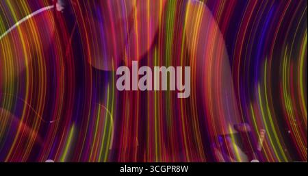 Streaming abstract light trails filling dimly lit space, with vivid multicolor arcs Stock Photo