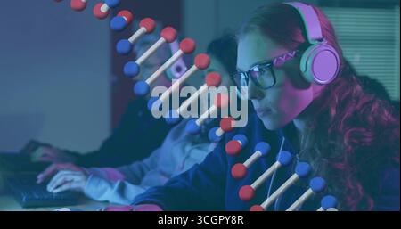 Analyzing researcher with glasses and headset studying monitors in research lab with 3D DNA helix Stock Photo