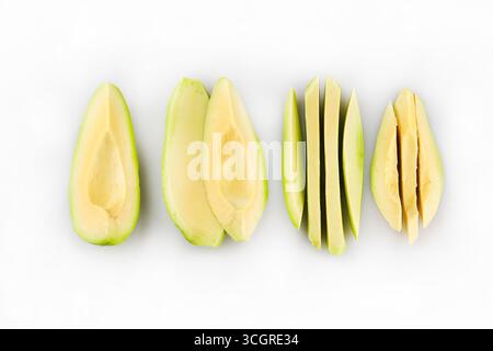 Falling avocado slices isolated on white background. Pieces of ripe avocado. Floating avocado fruits in the air Stock Photo