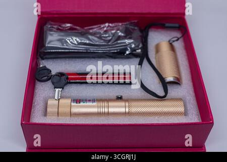 Gold Laser Pointer Set with Keys and Accessories in Red Gift Box on White Background Stock Photo