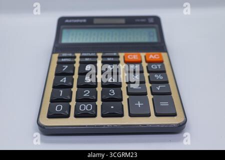 Modern Black and Gold Calculator with Large Buttons on White Surface Stock Photo