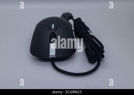 Modern Black USB Optical Mouse with Braided Cable on White Tabletop Background Stock Photo