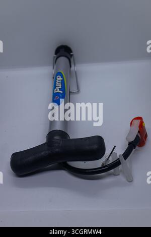 Portable hand air pump with attached hose on clean background Stock Photo