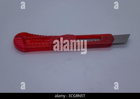 Retractable Blade Red Utility Knife for Office and Craft Use on White Background, Stock Photo