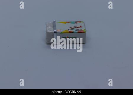 Small Wrapped Eraser with Rainbow Stripe Design on Plain Surface Stock Photo