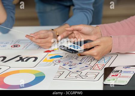 UX and UI Design Team Collaborating with Sketches and Smartphone Stock Photo
