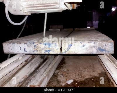 A stone cutting machine is actively being operated in a workshop, expertly shaping large stone slabs for various construction and art projects. Stock Photo
