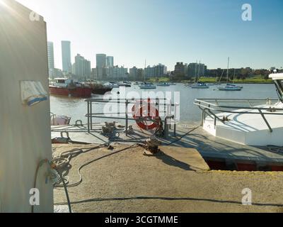 Electric charging station for boats, on a pier, with an urban landscape in the background. Stock Photo