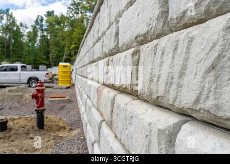 Newly installed commercial precast concrete block retaining wall on a construction site. Stock Photo
