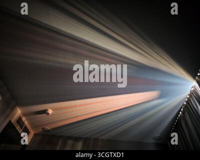 Multicolored Sunlight Beams Reflected Through Curtains Onto Ceiling Stock Photo