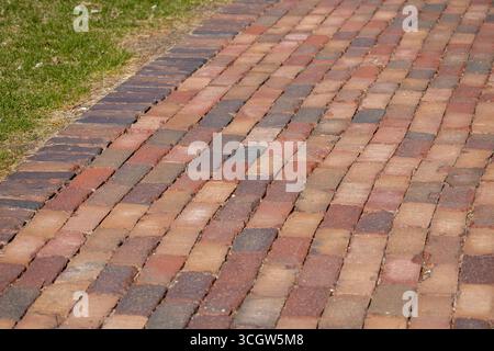 Full frame texture background of a colorful vintage red hued brick cobblestone pedestrian walkway Stock Photo