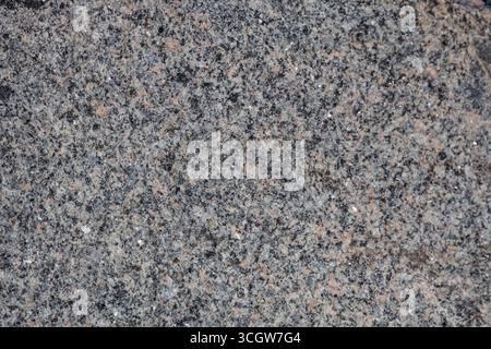 Macro abstract texture background of a multicolor natural granite stone boulder surface Stock Photo