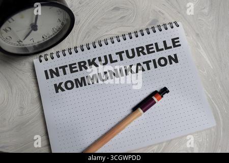 Concept of interkulturelle kommunikation write on book isolated on Wooden Table. Stock Photo