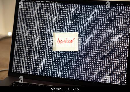Computer hacked, note on the screen of a laptop, warning sign. Computer error, note on the screen of a laptop, warning sign. Defect, malfunction, error, interruption, binary code, failure, noise, break down, computer bug, interference, device screen. technology computer hacked B97A8638 Stock Photo