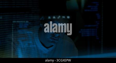 Programmers and coding. Programmer or Developer working in dark room with computer code reflected on their monitor. Cybersecurity software development Stock Photo
