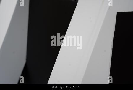 black and white close up abstract of white structure with shadows creating geometric shapes lines and angles horizontal image with black or white fram Stock Photo
