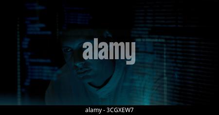 Programmers and coding. Programmer or Developer working in dark room with computer code reflected on their monitor. Cybersecurity software development Stock Photo