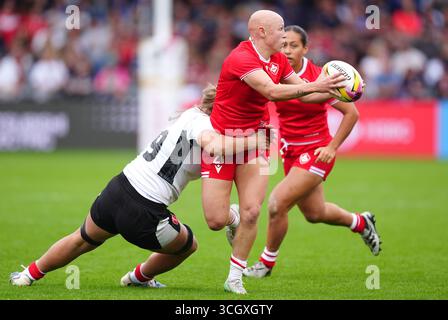 Canada's Olivia Apps, centre, is tackled by England's Zoe Aldcroft ...