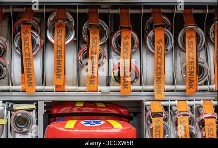 Firefighter equipment storage with rolled hoses and emergency medical bag inside firetruck compartment, organized rescue tools with connectors, straps Stock Photo