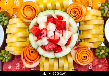Decorative fruit salad on a fruity background. Sliced watermelon, melon, pineapple and grapefruit. Stock Photo