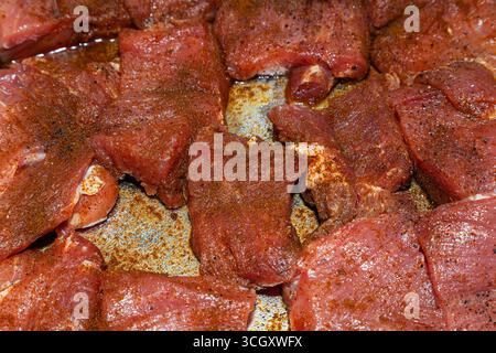 Pieces of juicy, fresh beef in spices, close-up. Beef raw steaks, top view. Stock Photo