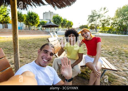 Three happy friends taking a selfie in a city park Stock Photo
