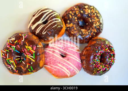 Sweet Donuts with Pink and Chocolate Toppings on White Background. Stock Photo